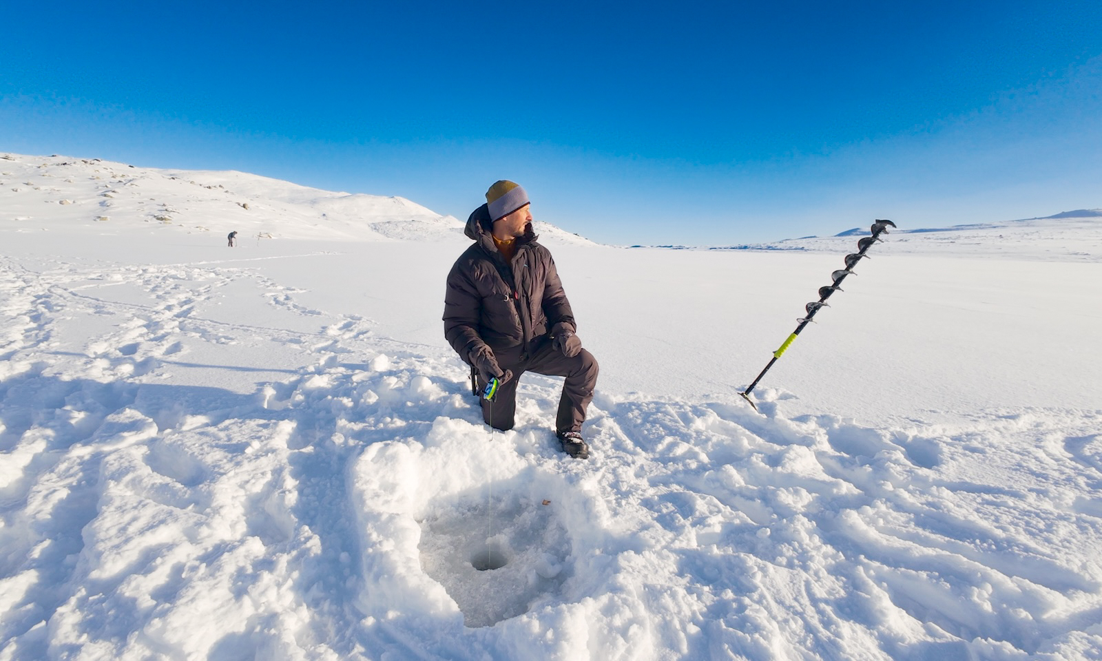 Drilling holes and setting up ice fishing gear